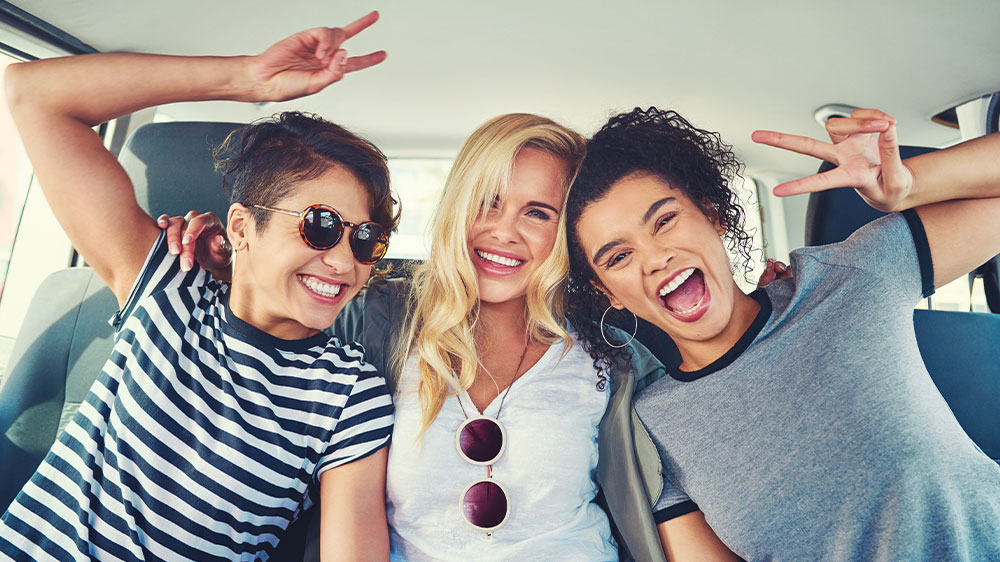 Usmievavé ženy v aute počúvajúce hudbu _02