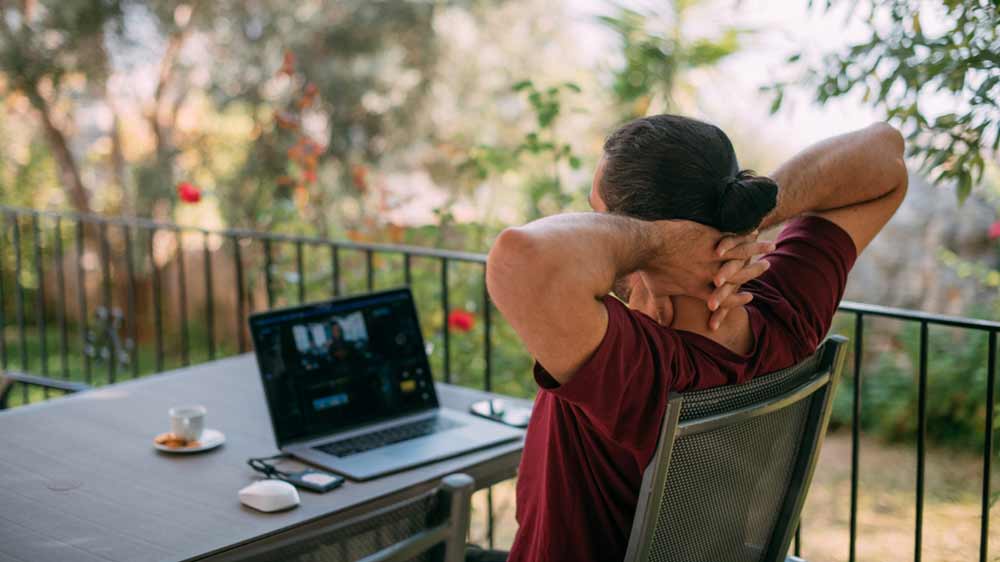 Muž sedí na terase s notebookem_02