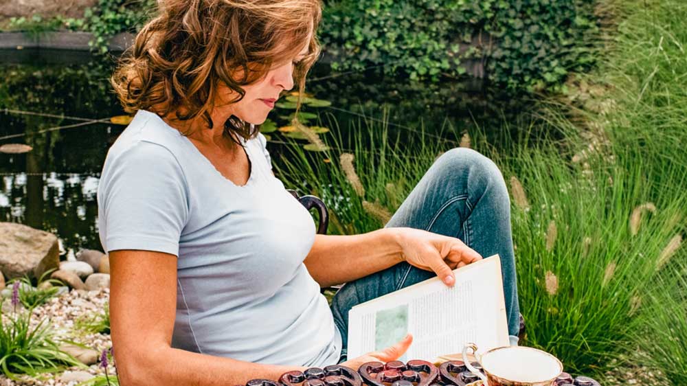 Žena sedící na zahradě si čte_02