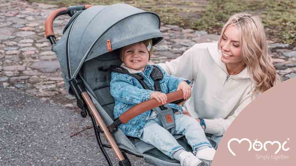 Mal&yacute; chlapec sed&iacute;c&iacute; ve sportovn&iacute;m koč&aacute;rku MoMi ESTELLE Light a vedle něj maminka_02