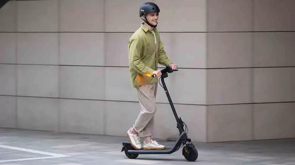 Muž ide na elektrickej kolobežke Segway eKickScooter E2 E II