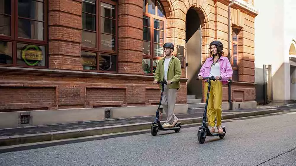 Muž a žena na elektrických kolobežkách Segway eKickScooter E2 Plus E II