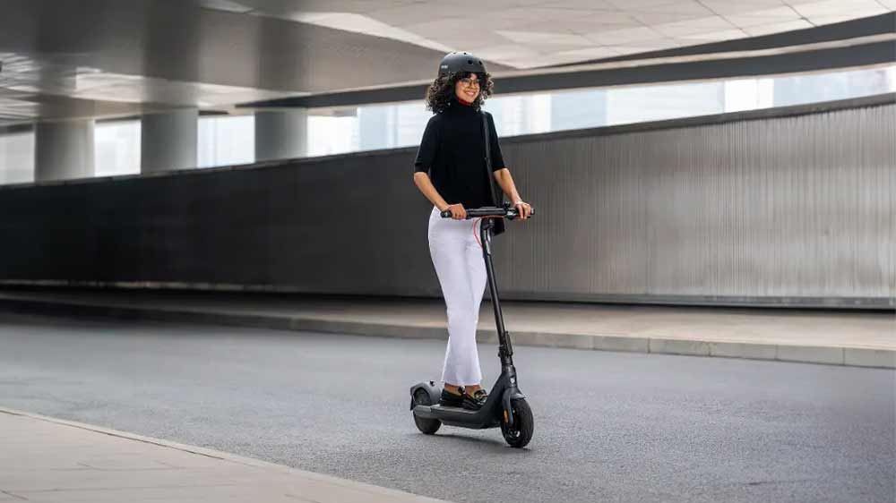 Žena jede na elektrick&eacute; koloběžce Segway KickScooter Ninebot E2 Pro E_02