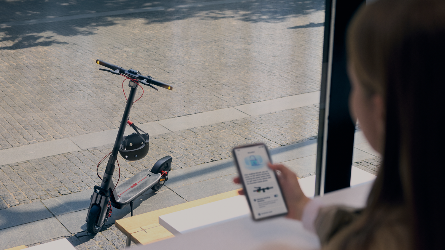 Žena s mobilem před elektrokoloběžkou Segway Ninebot F3 Pro E eKickScooter