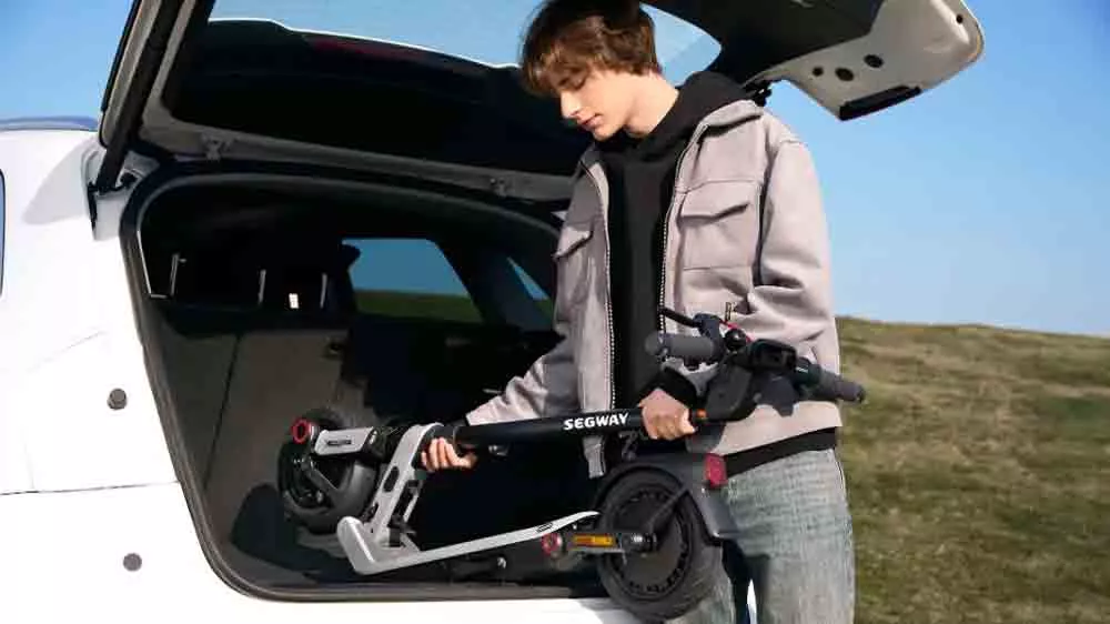 Muž vloží kolobežku Segway eKickScooter Ninebot E3 E do kufra auta_5