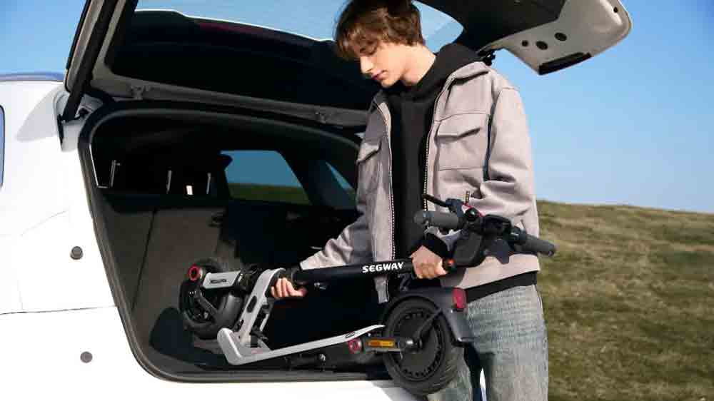 Muž skládá koloběžku Segway eKickScooter Ninebot E3 Pro E do kufru auta_02