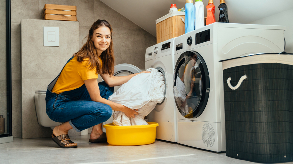 Mladá žena vyndává prádlo z pračky_01