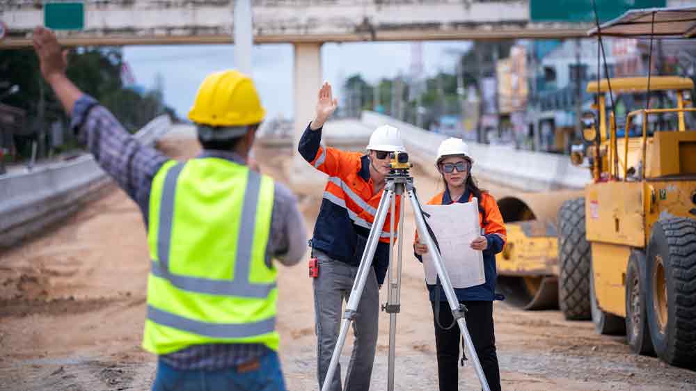 Ľudia na stavenisku pracujú so zariadením umiestneným na statívu_03