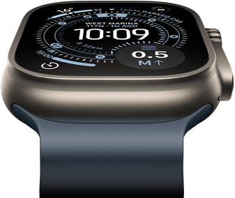 Apple Watch Ultra 3 nakloněné dopředu, pouzdro z přírodního titanu, kompas na ciferníku Orientační běh, ocelově modrý Oceánský řemínek