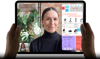 iPad Pro, pohled zepředu, orientace na šířku, vesmírně černá barva, zaoblené rohy, černý rámeček displeje, ruce drží levou a pravou stranu, na displeji se zobrazuje FaceTime konverzace překládaná v reálném čase a vzdělávací aplikace s prezentací na téma komparativní mytologie, textem, diagramy a ručně psanými poznámkami