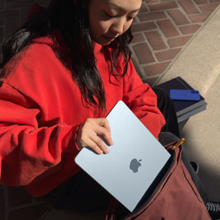 Studentka si dává 15palcový MacBook Air do batohu