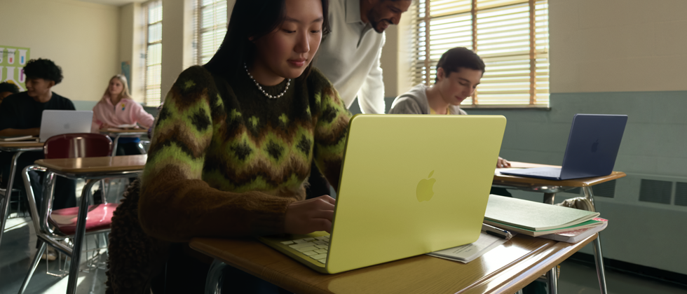 Študentka používa odpojený MacBook Neo v citrusovej farbe v triede