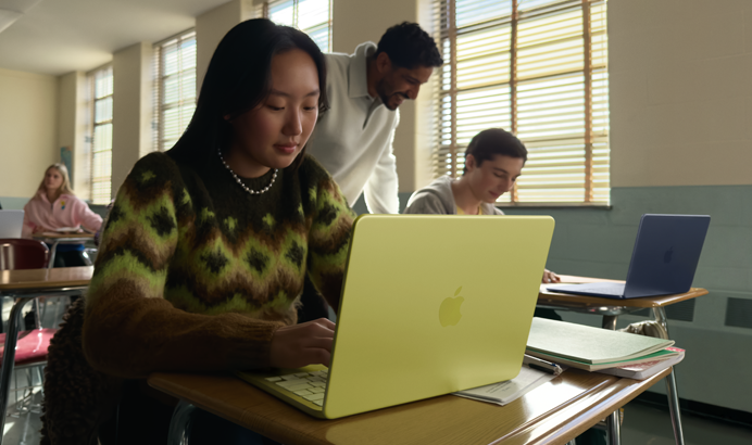 Študentka používa odpojený MacBook Neo v citrusovej farbe v triede