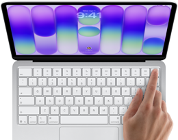 MacBook Neo v striebornej farbe zobrazuje prihlasovaciu obrazovku, niečí prst na senzore Touch ID v pravom hornom rohu klávesnice