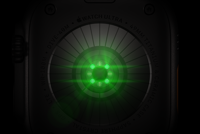 Pohled zezadu na Apple Watch Ultra 4, titanové pouzdro, černá barva, několik kulatých snímačů se svítícími zelenými LED diodami