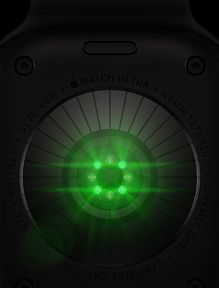 Pohled zezadu na Apple Watch Ultra 4, titanové pouzdro, černá barva, několik kulatých snímačů se svítícími zelenými LED diodami